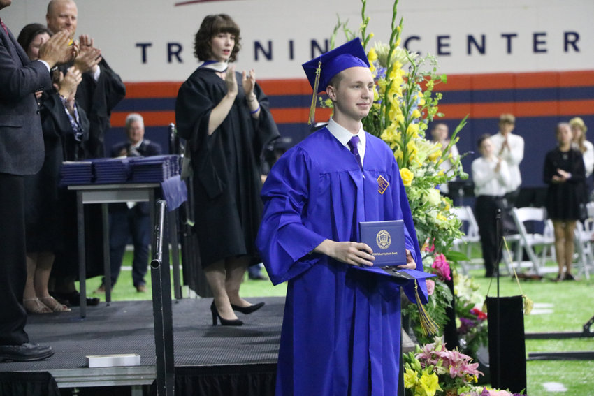 STEM School Highlands Ranch graduate Jordon Monk accepts Kendrick Castillo's diploma at a May 20 commencement ceremony at the Broncos Training Facility. Castillo was Monk's best friend.